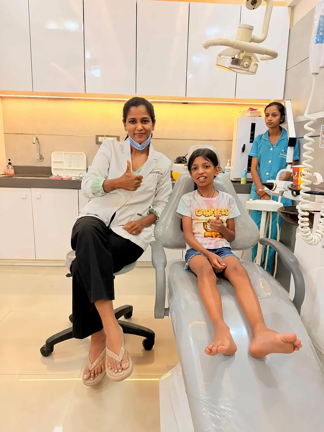 Dr. Supriya Holkar and a young patient on the dental chair, with the clinic assistant
