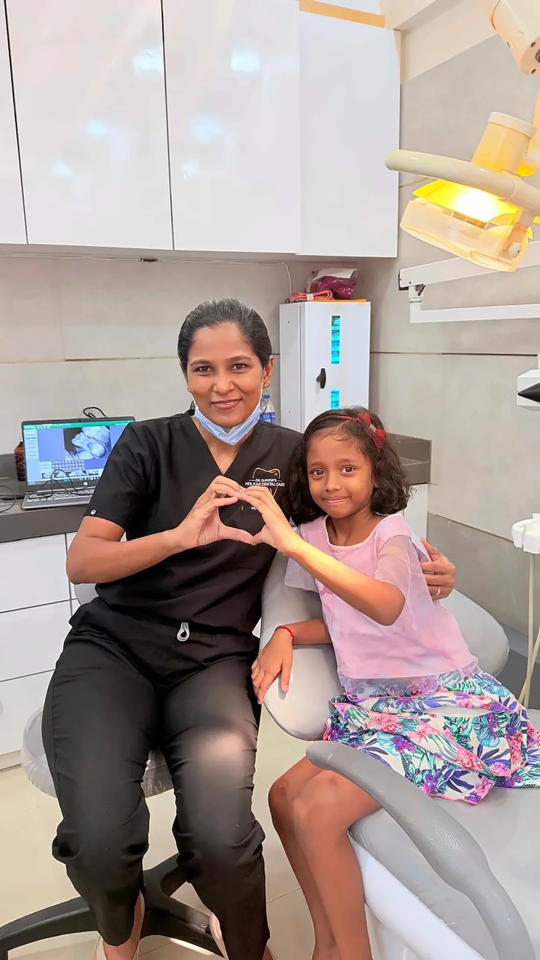Dr. Supriya Holkar making a heart sign with a young patient